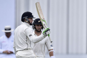 Martin Guptill (L) of New Zealand celebrates 50 runs with team mate Kane Williamson (Back) during day one of the first International Test cricket match between New Zealand and Sri Lanka
