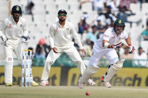 South Africa's Dean Elgar (R) makes a run as India's wicketkeeper Wriddhiman Saha (L) and captain Virat Kohli look on during the third day of the first Test match between India and South Africa ©AFP